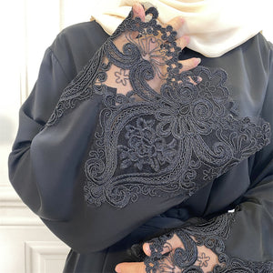 Luxury black nidha abaya featuring sheer embroidered lace sleeves and a matching belt.